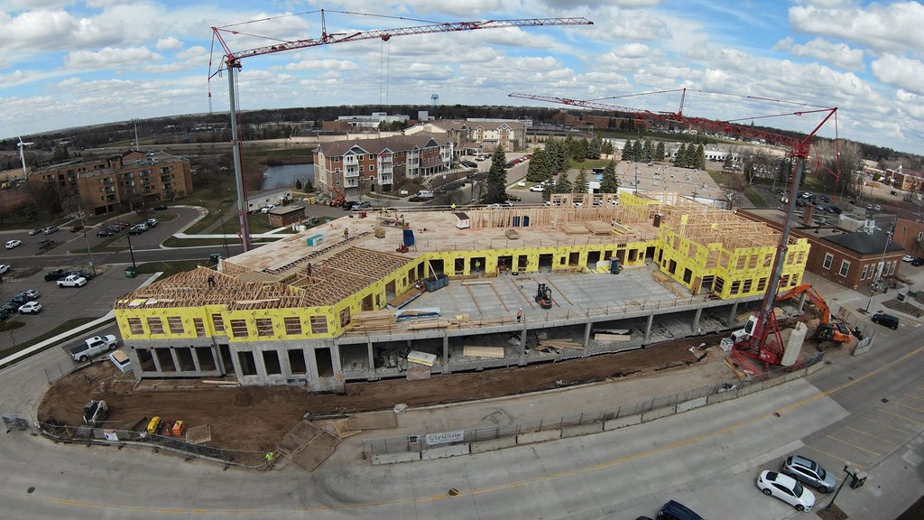 a large yellow building is being constructed in a parking lot