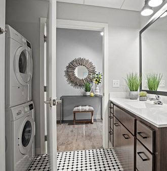 a bathroom with a washer and dryer and a sink