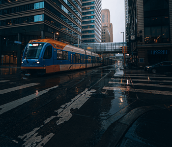 a train on a city street in the rain