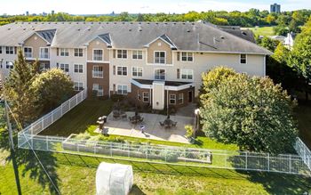 Apartment complex with a green lawn and trees.