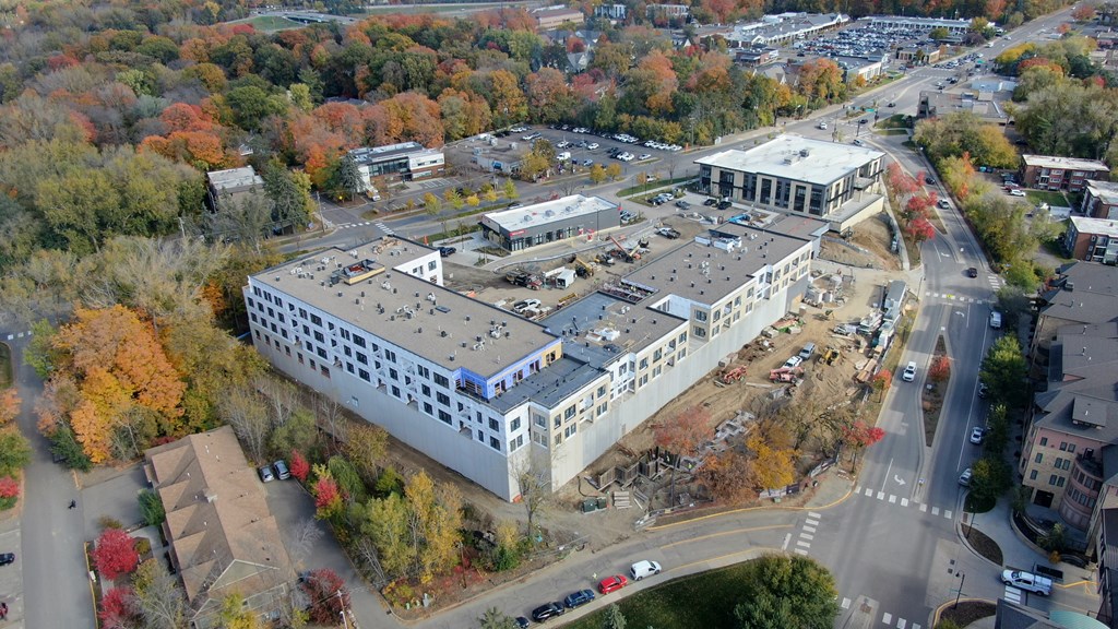 An aerial view of a large building surrounded by trees with autumn foliage.