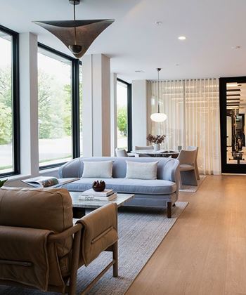 A modern living room with a grey couch and a brown armchair.