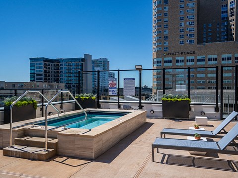 the pool on the rooftop of a building with a city in the background