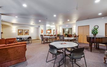 A room with a round table surrounded by chairs.