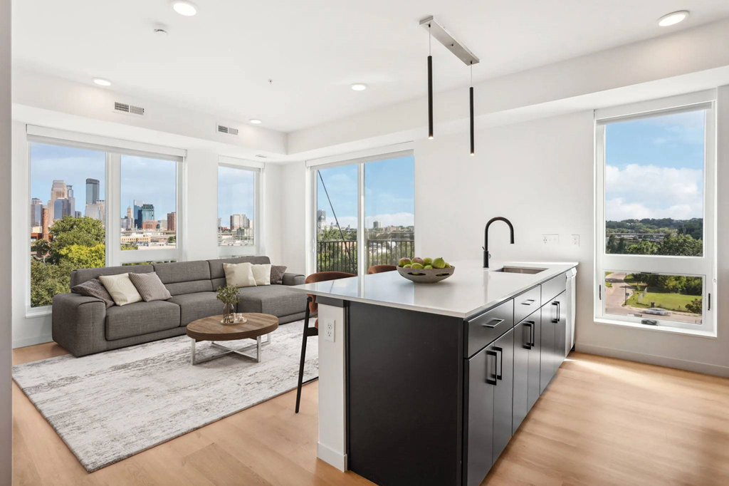 A modern kitchen and living room with a view of the city.