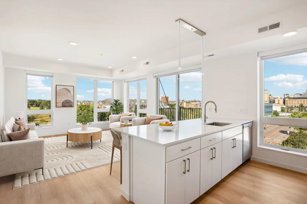 A modern kitchen with white cabinets and a large island.