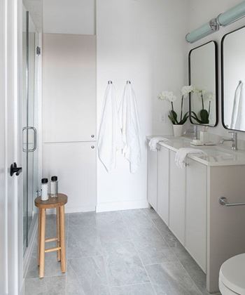 A white bathroom with a towel hanging on the towel rack.