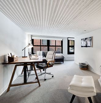 a home office with a wooden desk and white walls