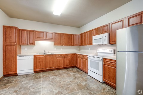A kitchen with wooden cabinets and white appliances.