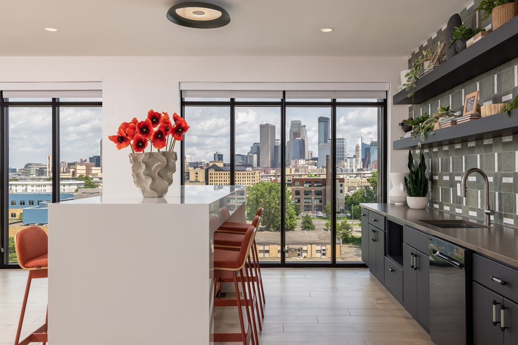 A kitchen with a view of the city skyline.