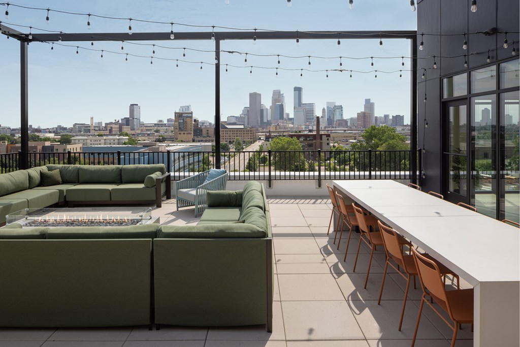 A patio with a table and chairs overlooking a city skyline.