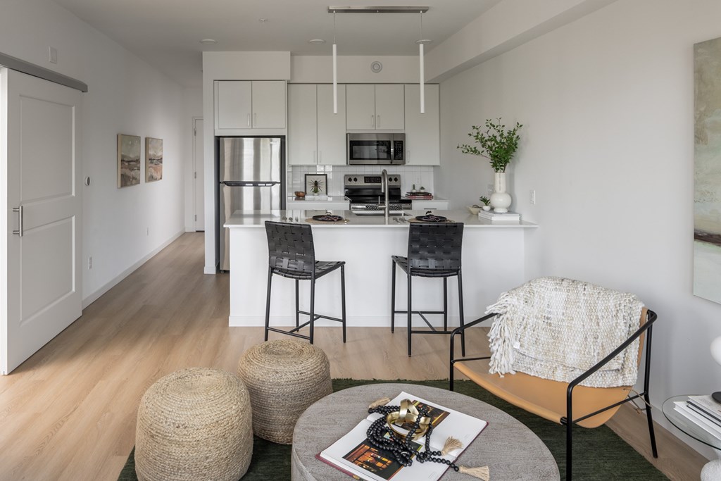A modern kitchen with white cabinets and a dining area with a table and chairs.