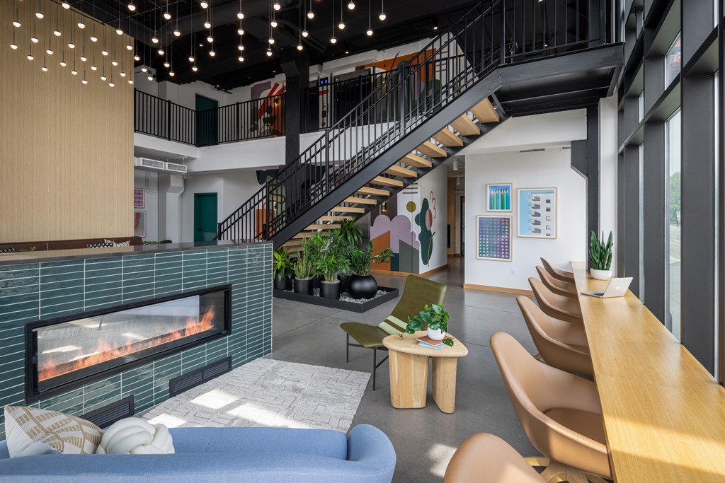A living room with a fireplace and a staircase.