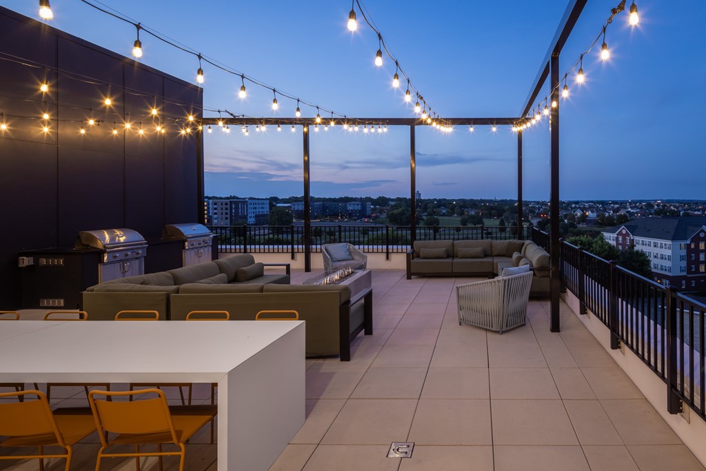 A rooftop patio with a table and chairs.