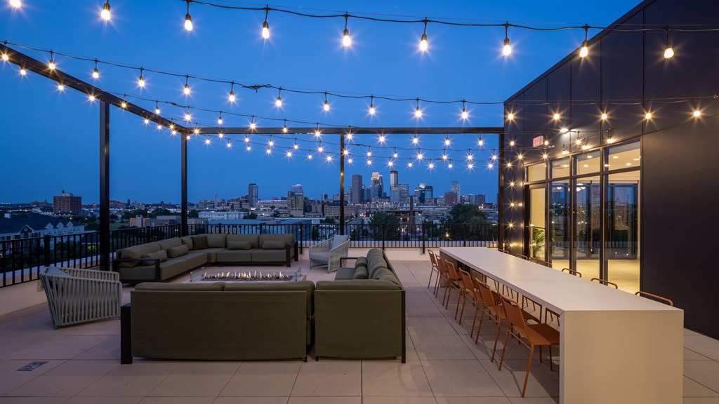 A rooftop patio with a bar and seating area.