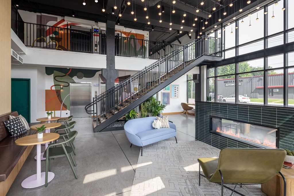 A modern interior with a staircase, a fireplace, and a seating area.