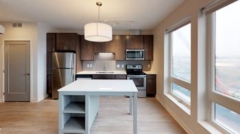 a modern kitchen with a white island and stainless steel appliances