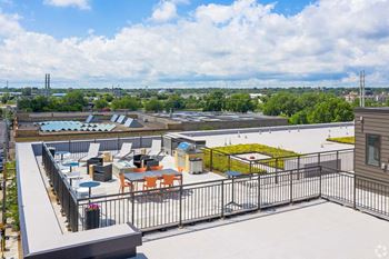 a rooftop patio with tables and chairs on top of a building