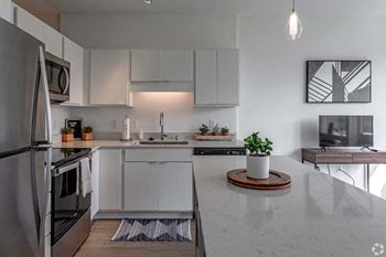 a white kitchen with a counter top and a refrigerator