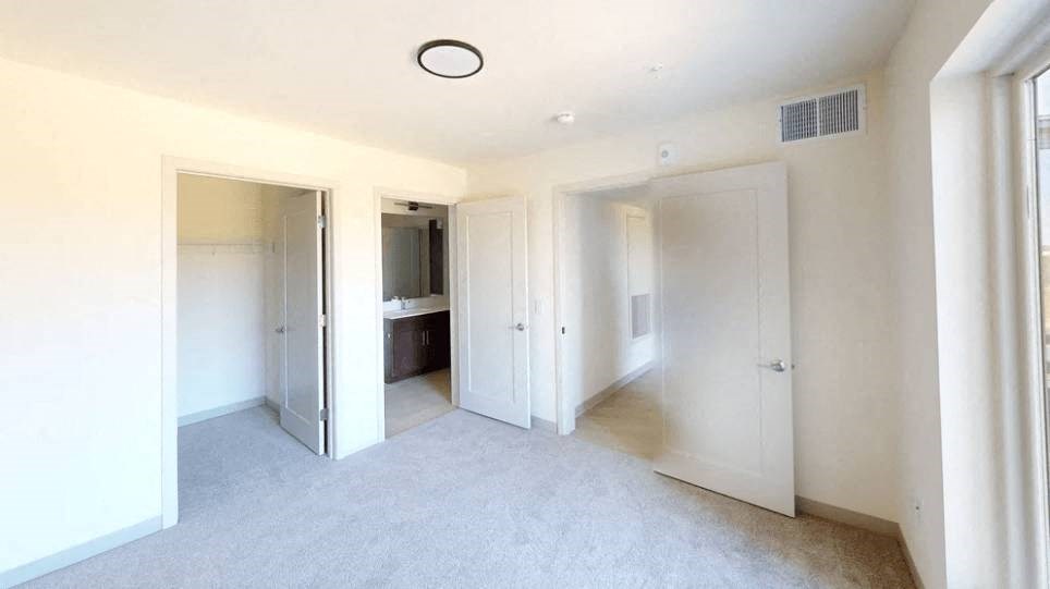 an empty living room with white walls and doors