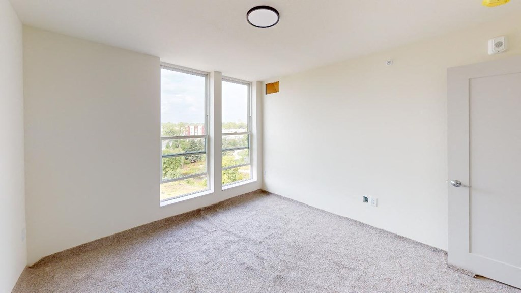 an empty room with white walls and a window