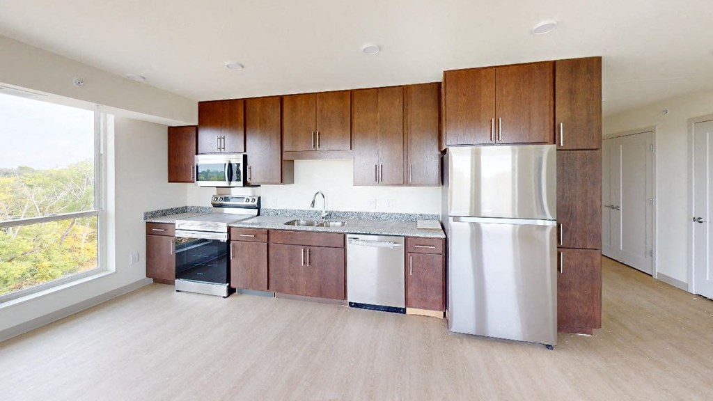 a kitchen with wooden cabinets and a stainless steel refrigerator
