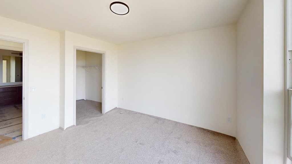 an empty living room with white walls and carpet