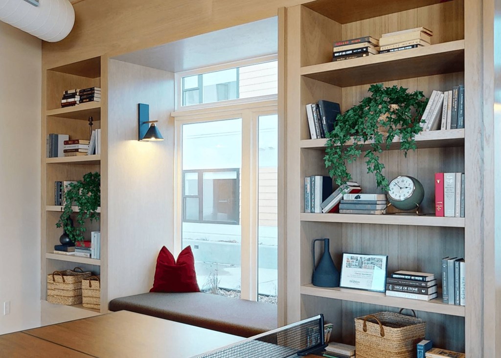 a living room with bookshelves and a window