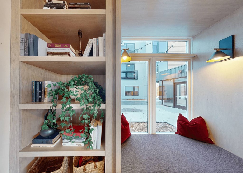 a bookshelf in a room with a window and a plant