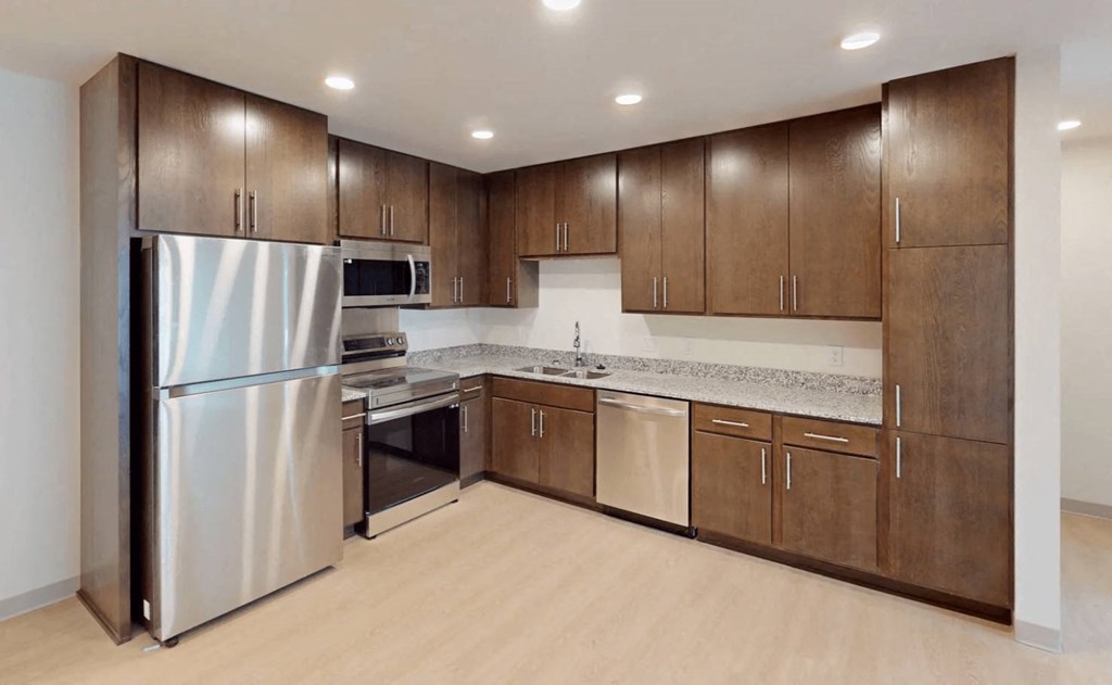 a large kitchen with stainless steel appliances and wooden cabinets