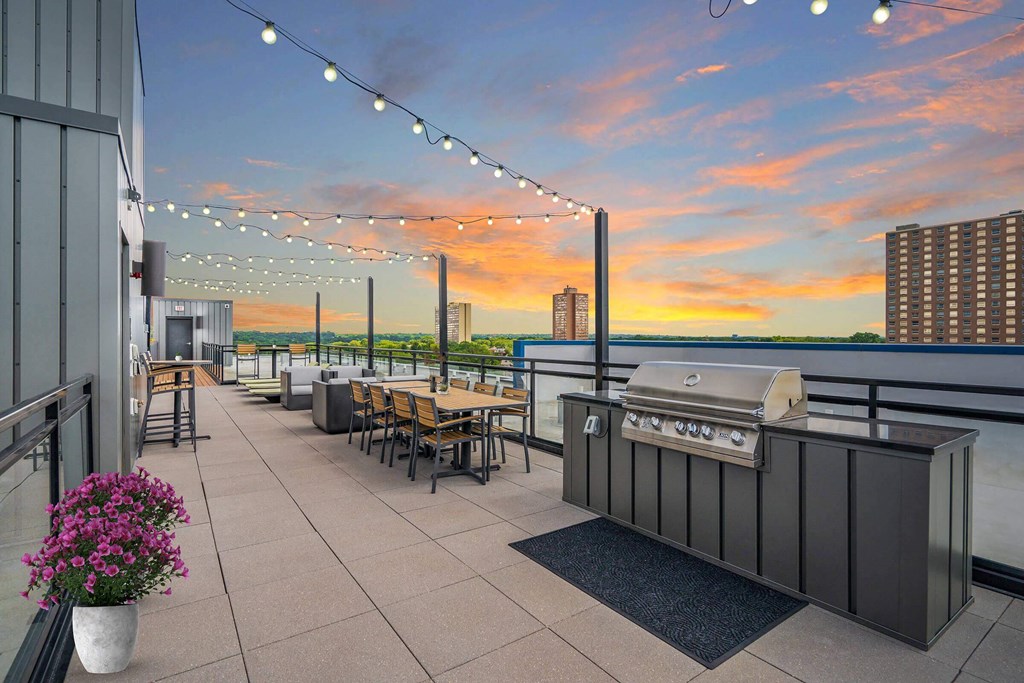 a rooftop bar with a view of the city and a sunset