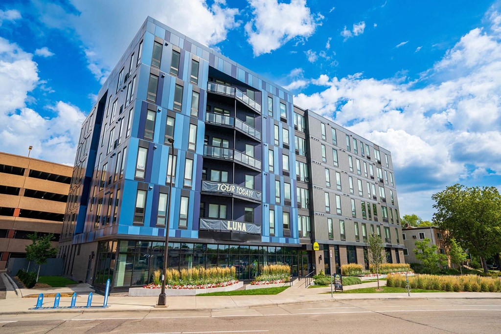 a large blue building with a street in front of it