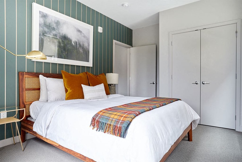 a bedroom with a bed and a painting on the wall