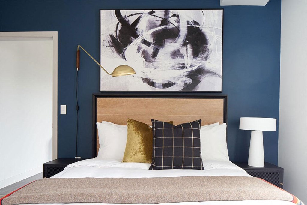 a bedroom with a bed and a painting on the wall