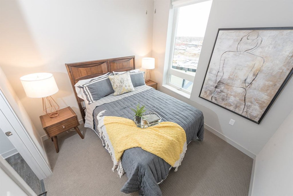 a bedroom with a bed and a painting on the wall