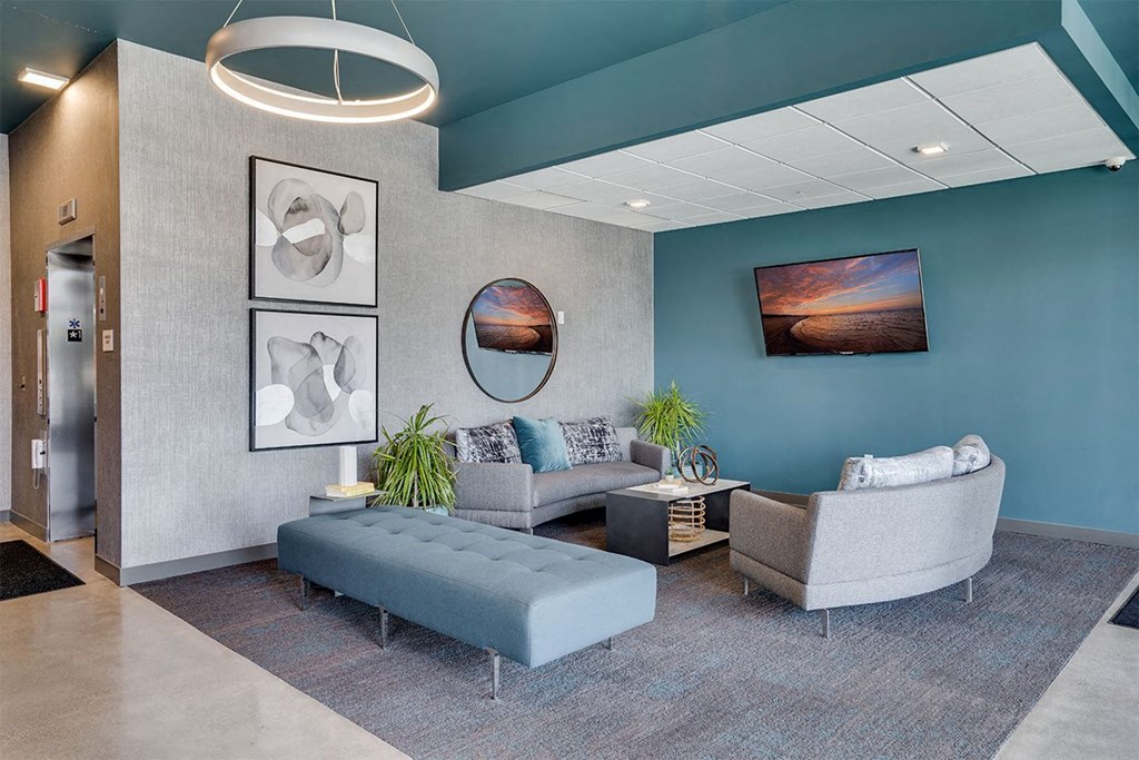 a lobby with couches and chairs and pictures on the wall