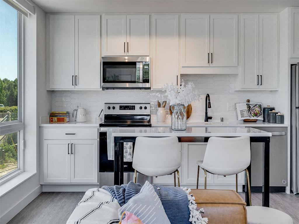 a white kitchen with a table and chairs and a microwave