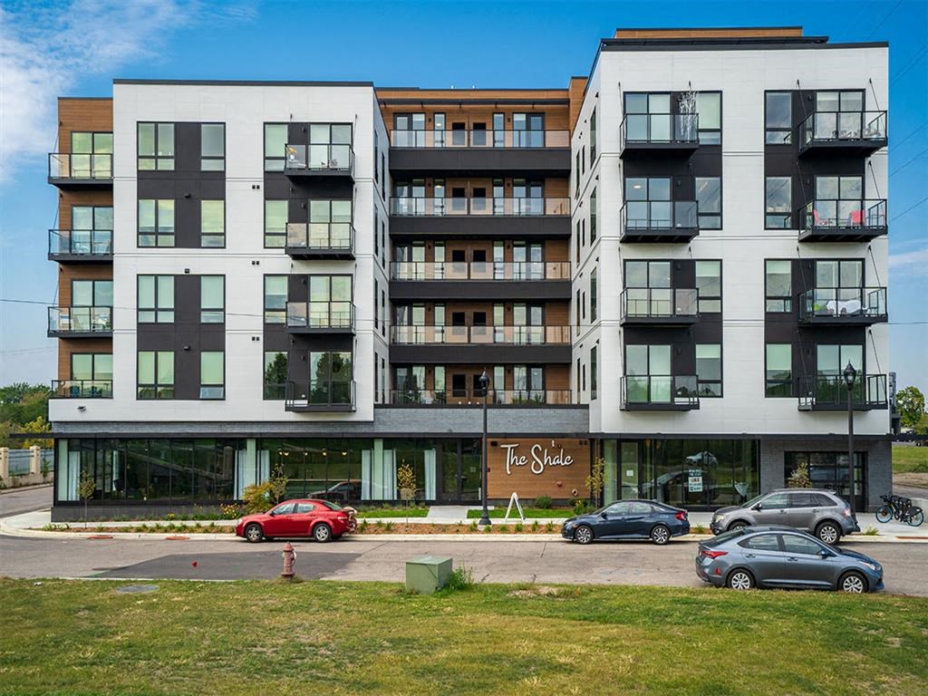 a large apartment building with cars parked in front of it
