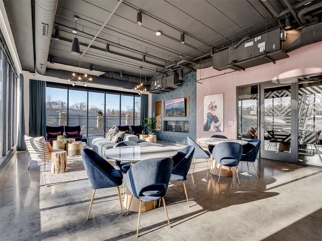 a rendering of a living room with tables and chairs and large windows