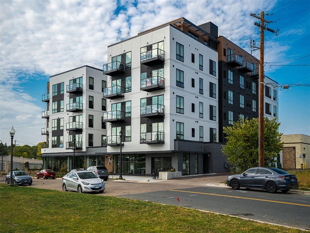 a new apartment building on a city street with cars