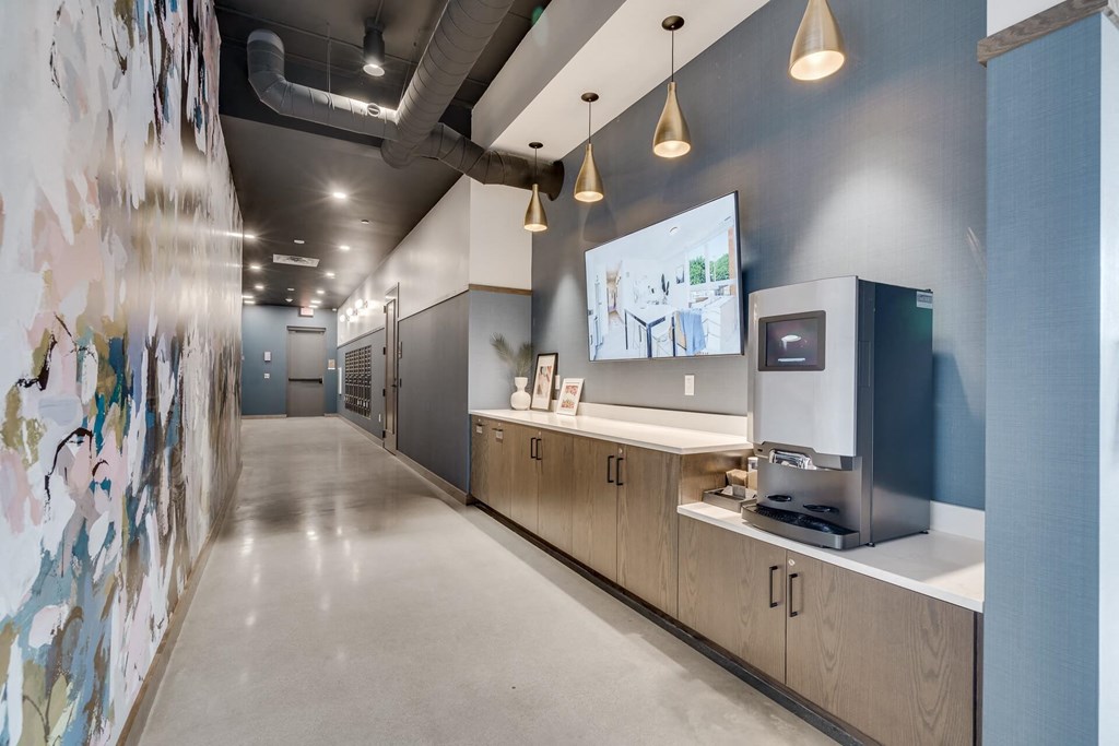 a hallway with a coffee machine and a wall with a painting