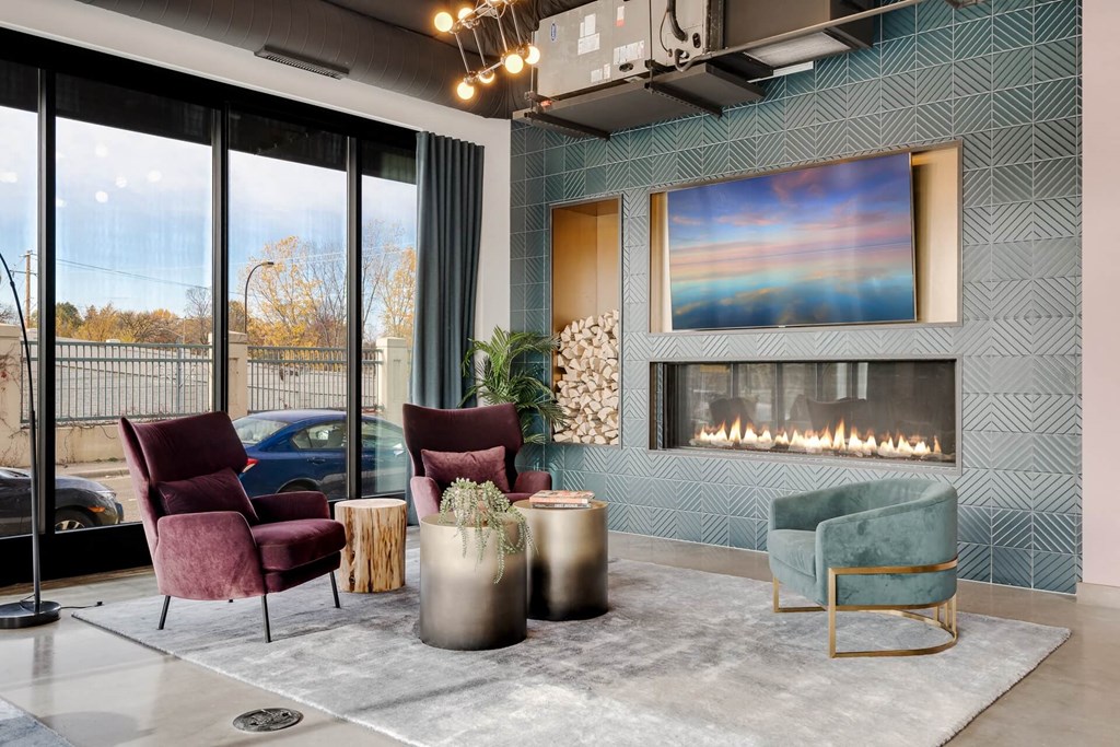 a living room with chairs and a fireplace