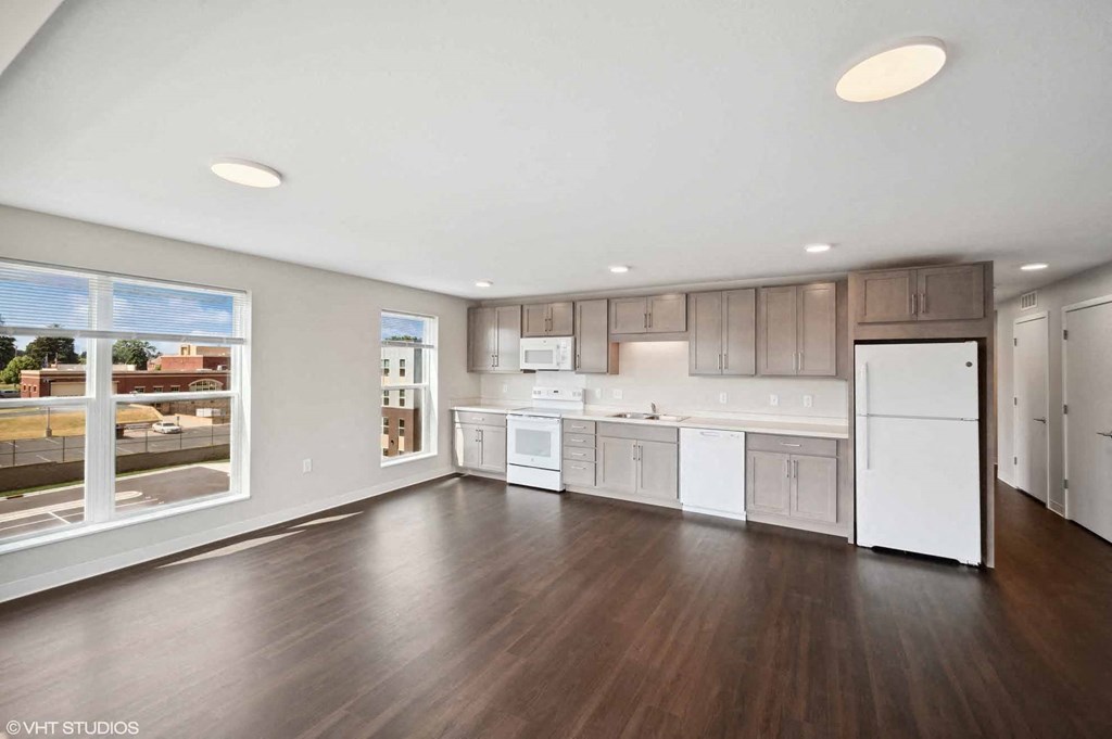 an open kitchen with a large window and a white refrigerator