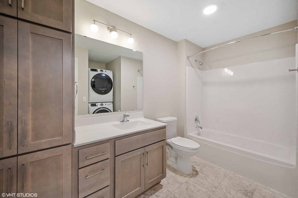 a bathroom with a toilet sink and a washer and dryer in it