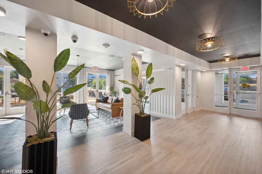 a lobby with a couch and a chair and some plants