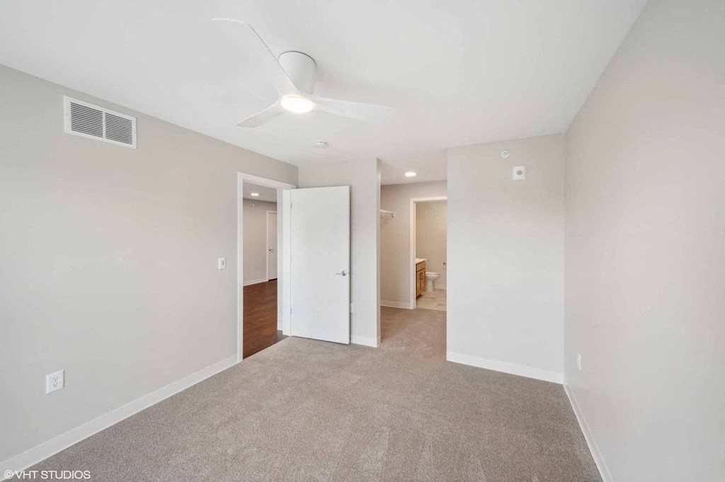 an empty living room with white walls and a ceiling fan