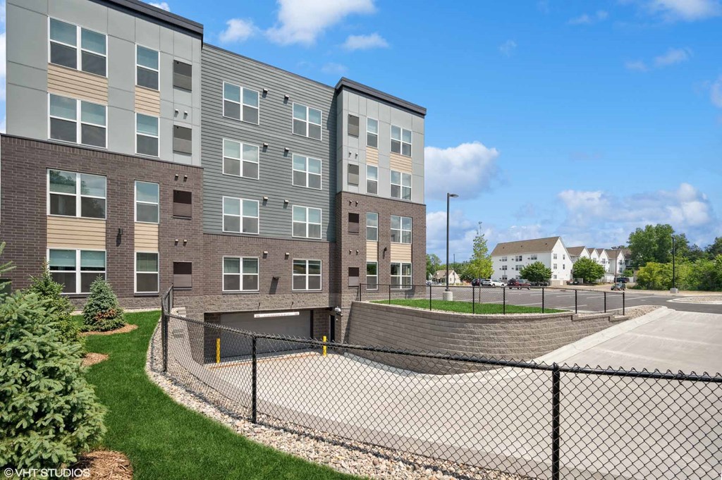 an apartment building with a fenced in tennis court