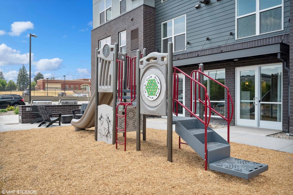 a playground in front of a building with stairs