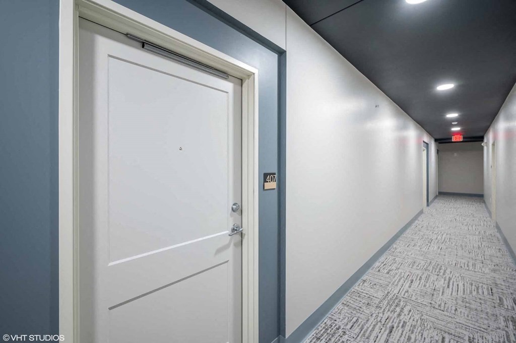 a hallway with white walls and a white door