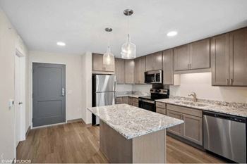 an updated kitchen with stainless steel appliances and granite counter tops